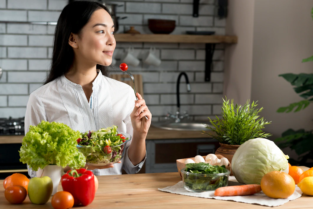 pretty-young-woman-eating-red-cherry-tomato-holding-bowl-mixed-salad_23-2148075984